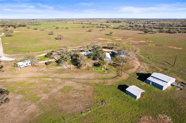 an aerial view of ocean and residential houses with outdoor space