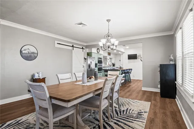 a view of a dining room with furniture a chandelier and wooden floor