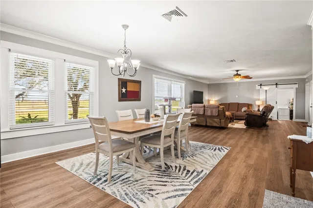 a living room with furniture a dining table and a chandelier
