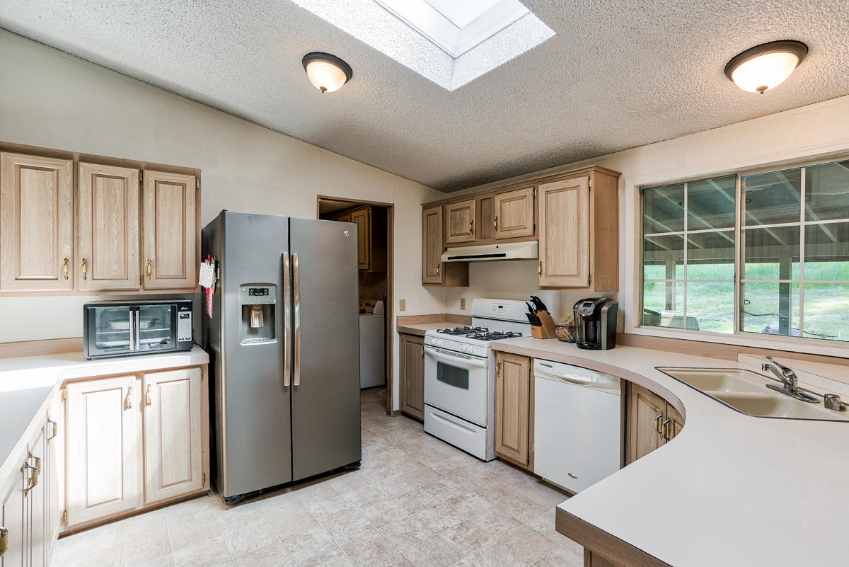 19555 Live Oak Road Red Bluff, CA 96080 - Photo 1 of 35 a kitchen with a sink a refrigerator a stove and white cabinets