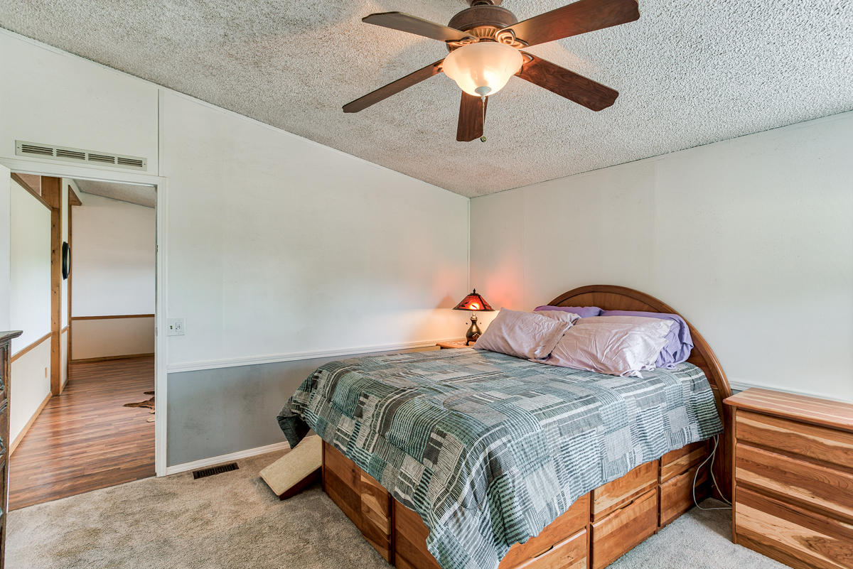 19555 Live Oak Road Red Bluff, CA 96080 - Photo 27 of 35 a bedroom with a bed and a chandelier