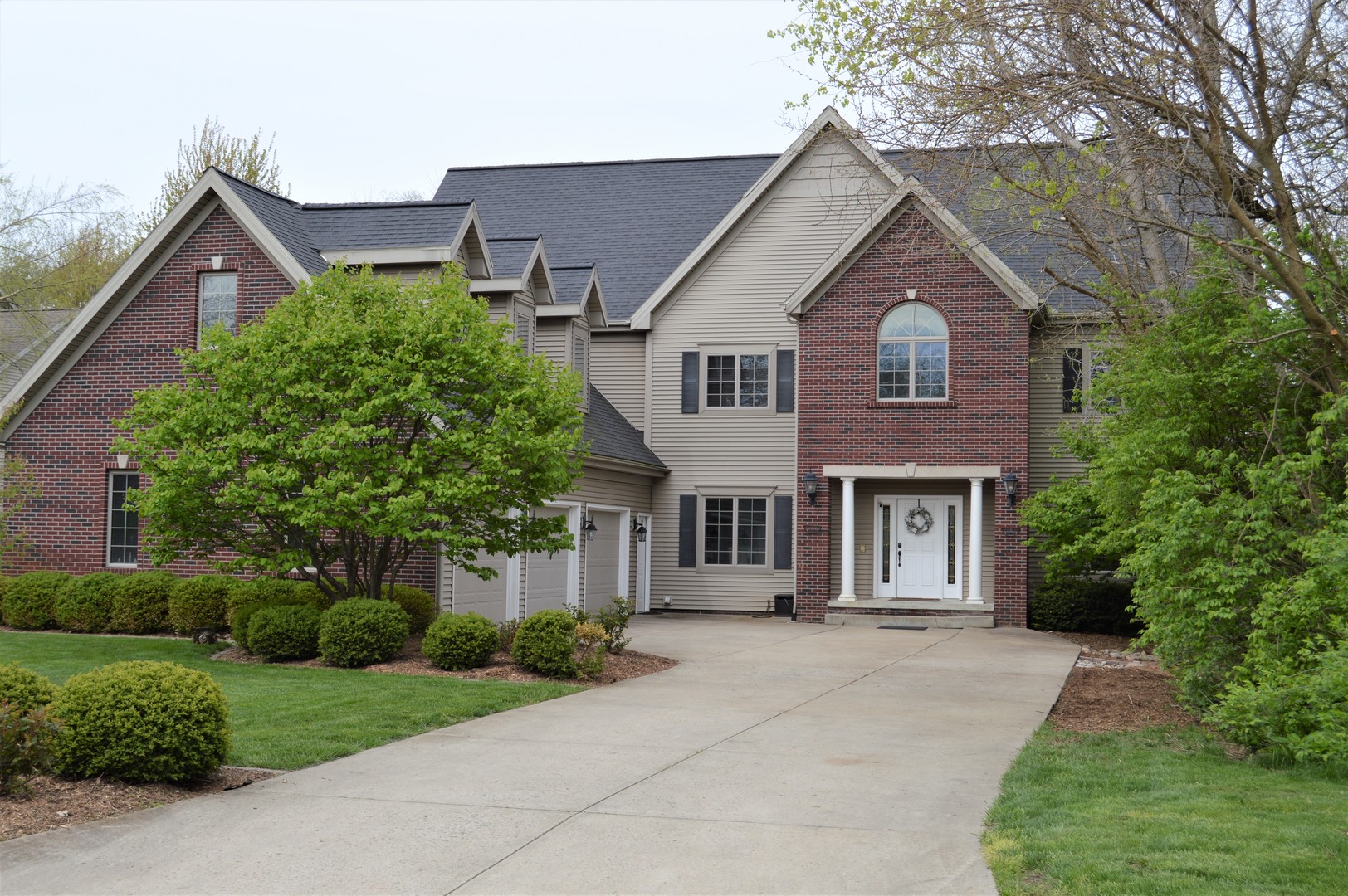 a front view of a house with a yard and trees