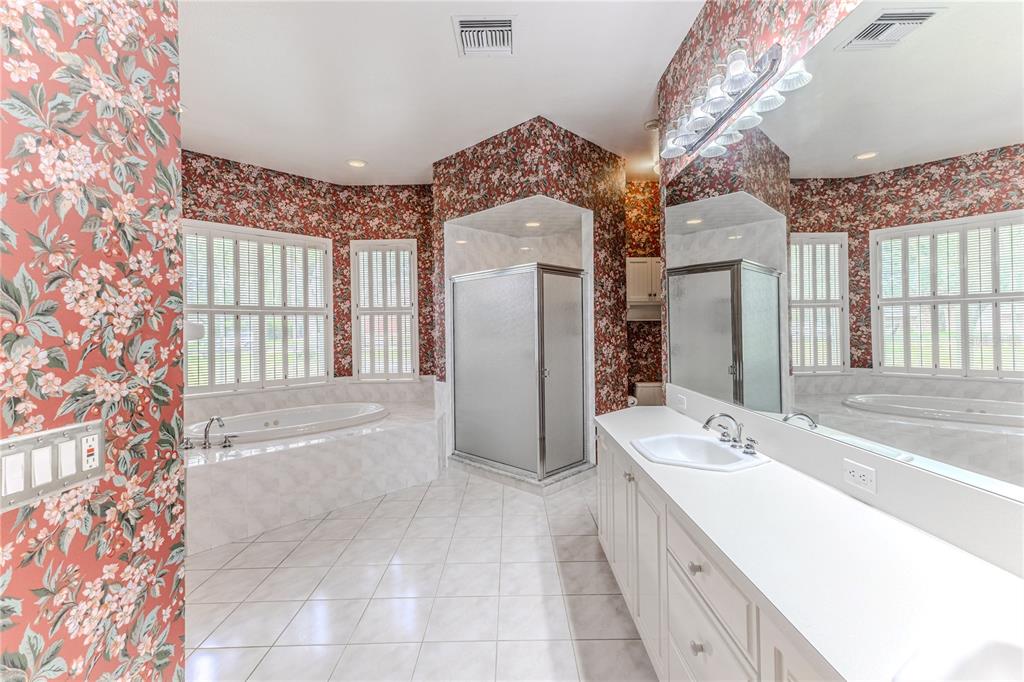 7512 Oak Tree Lane Spring Hill, FL 34607 - Photo 55 of 89 a spacious bathroom with a double vanity sink mirror and bathtub