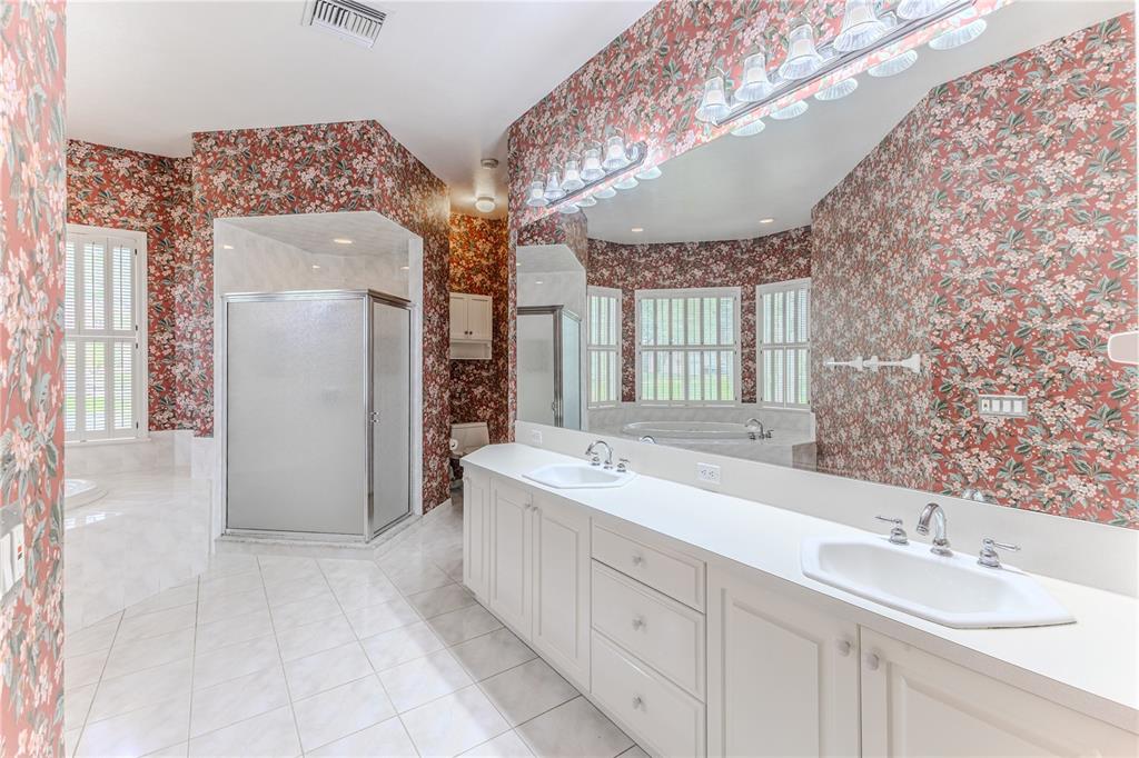 7512 Oak Tree Lane Spring Hill, FL 34607 - Photo 56 of 89 a spacious bathroom with a double vanity sink mirror and double