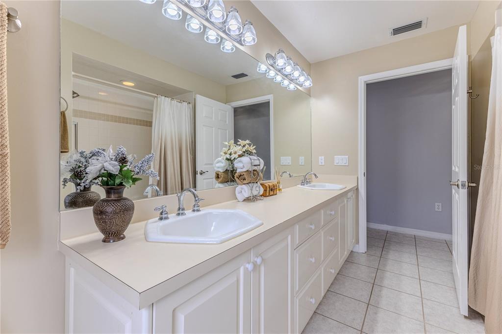 7512 Oak Tree Lane Spring Hill, FL 34607 - Photo 65 of 89 a bathroom with a sink a large mirror and a shower