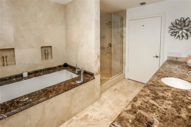 a bathroom with a tub sink and mirror