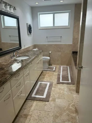 a spacious bedroom with a large bed and a chandelier