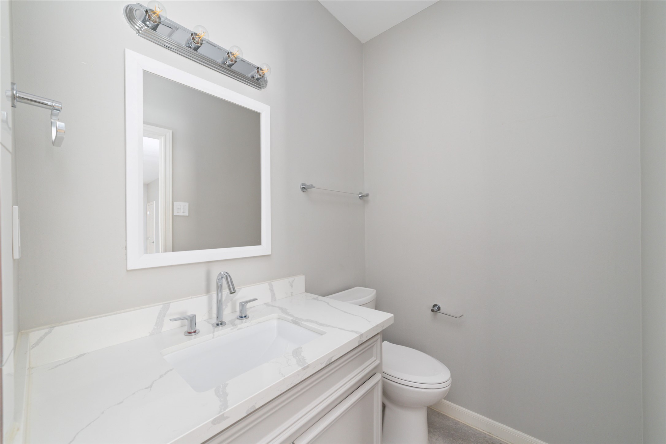 1516 Park Street, Unit B Houston, TX 77019 - Photo 12 of 20 a bathroom with a granite countertop sink a toilet and a mirror