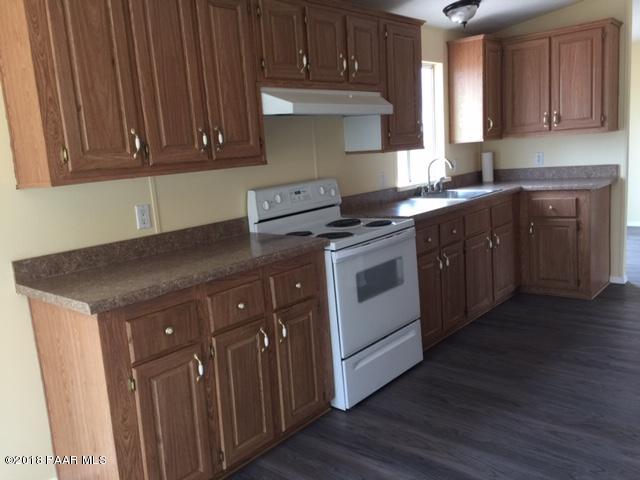 1725 West Big Sky Ranch Road Paulden, AZ 86334 - Photo 29 of 30 a kitchen with wooden cabinets and a stove top oven