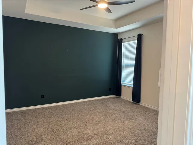 an empty room with a ceiling fan and a window