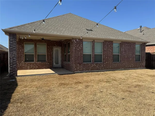 a view of a brick house with large windows