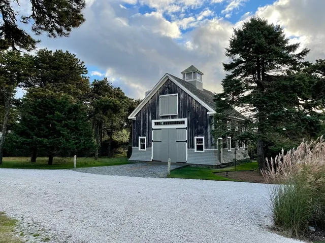 a view of a house with a big yard and large trees