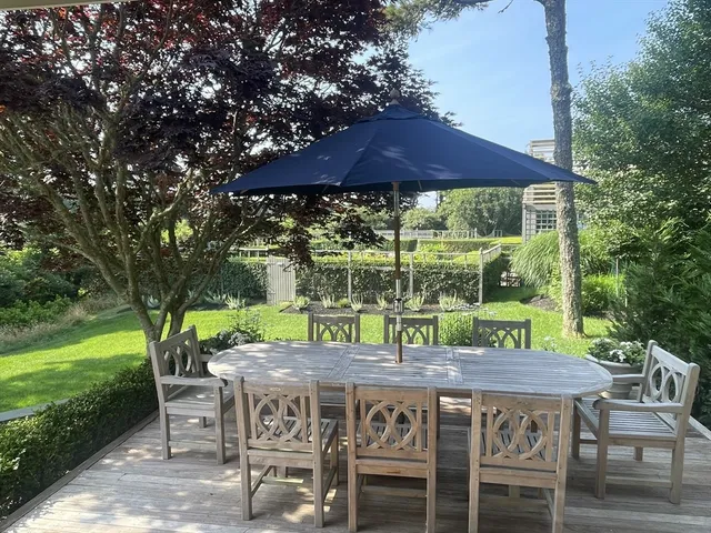 a backyard of a house with table and chairs