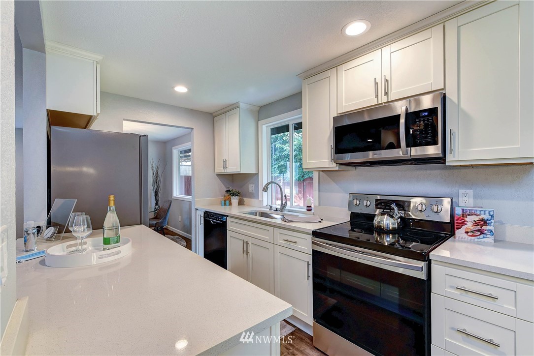 2623 171st Street Southeast Bothell, WA 98012 - Photo 11 of 26 a kitchen with stainless steel appliances a stove microwave sink and cabinets