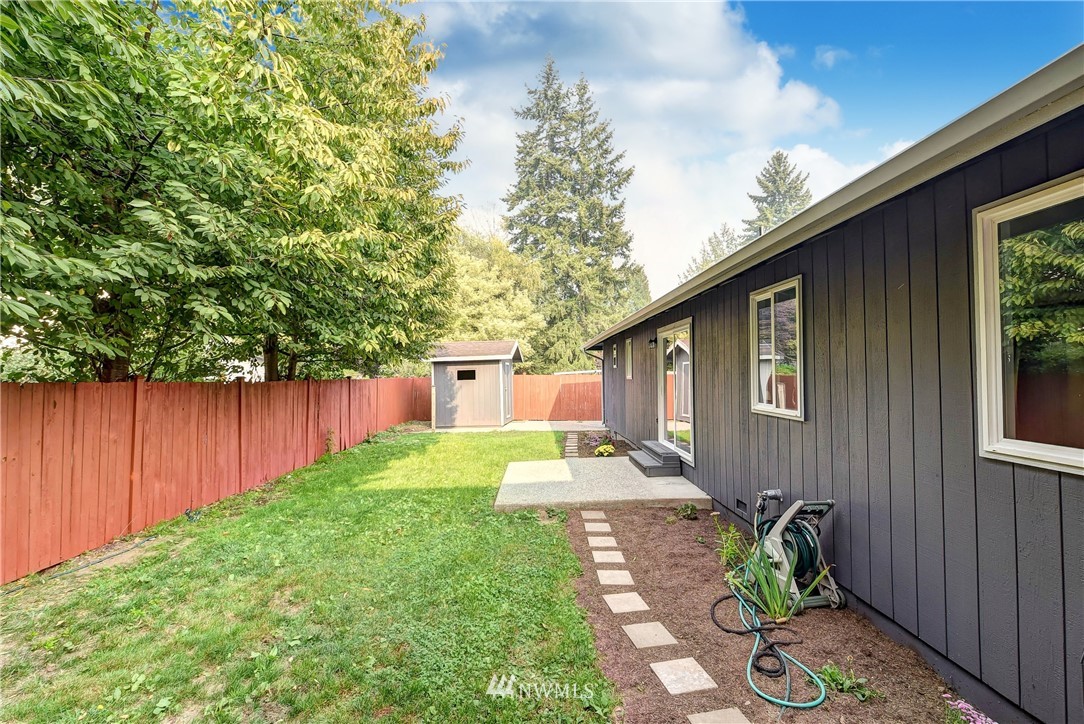 2623 171st Street Southeast Bothell, WA 98012 - Photo 22 of 26 a backyard of a house with chairs plants and large tree