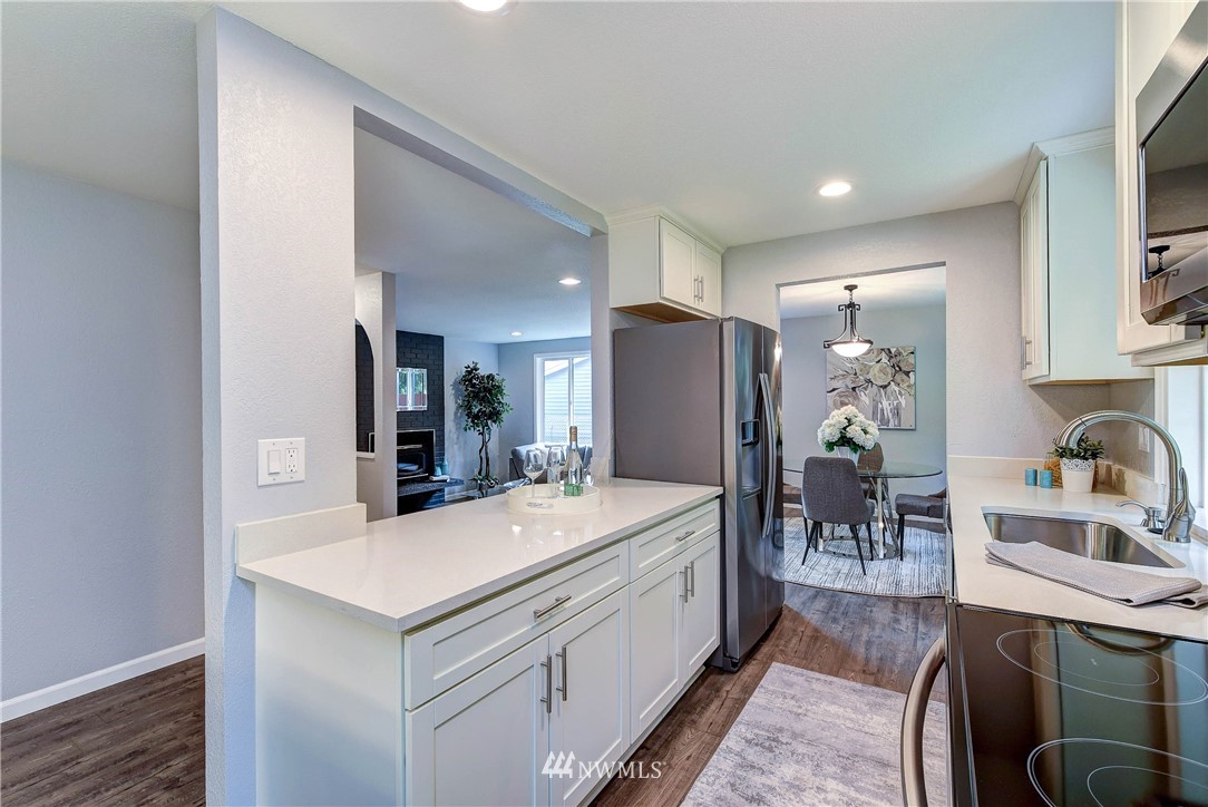 2623 171st Street Southeast Bothell, WA 98012 - Photo 10 of 26 a kitchen with a sink a refrigerator and chairs