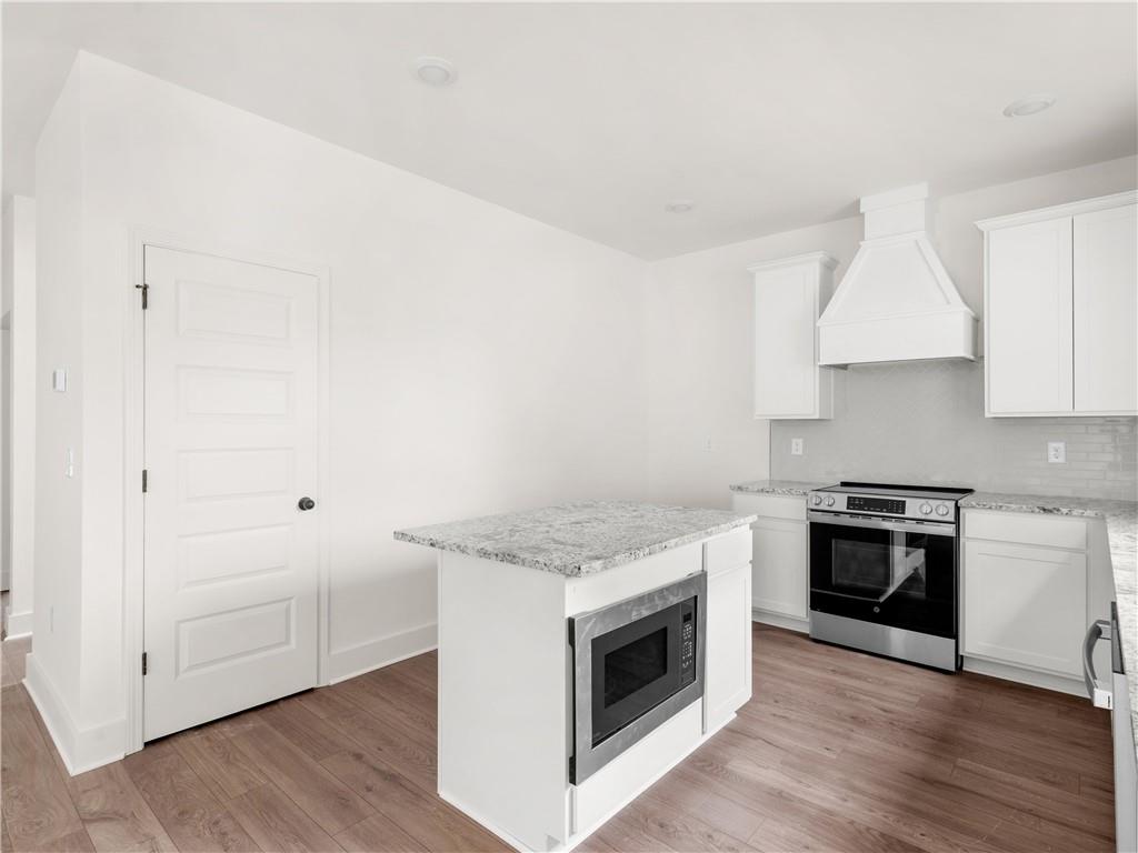 202 Loyd Road Mansfield, GA 30055 - Photo 17 of 23 a kitchen with granite countertop white cabinets and stainless steel appliances