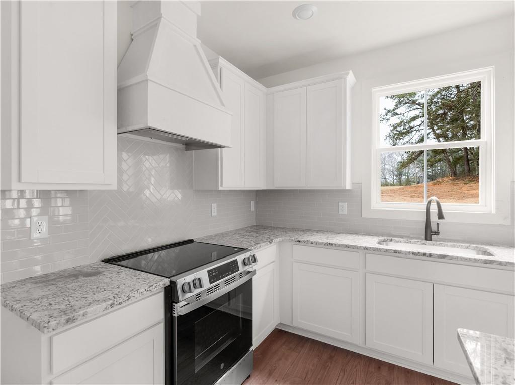 202 Loyd Road Mansfield, GA 30055 - Photo 22 of 23 a kitchen with granite countertop stainless steel appliances white cabinets granite counter tops and a wooden floors