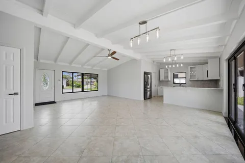 an empty room with window and bathroom