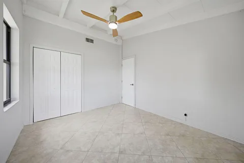 an empty room with a ceiling fan and a window