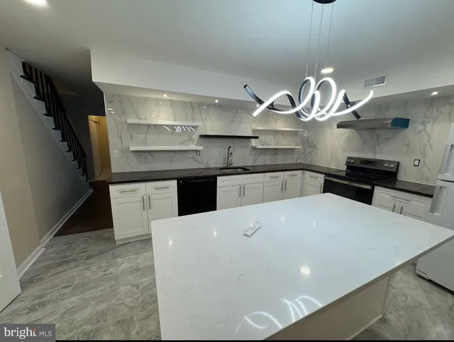 a large kitchen with stainless steel appliances a large counter top