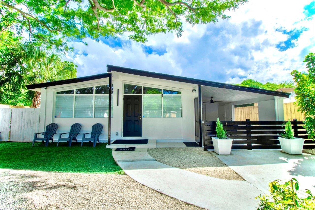 a front view of a house with a garden and chairs