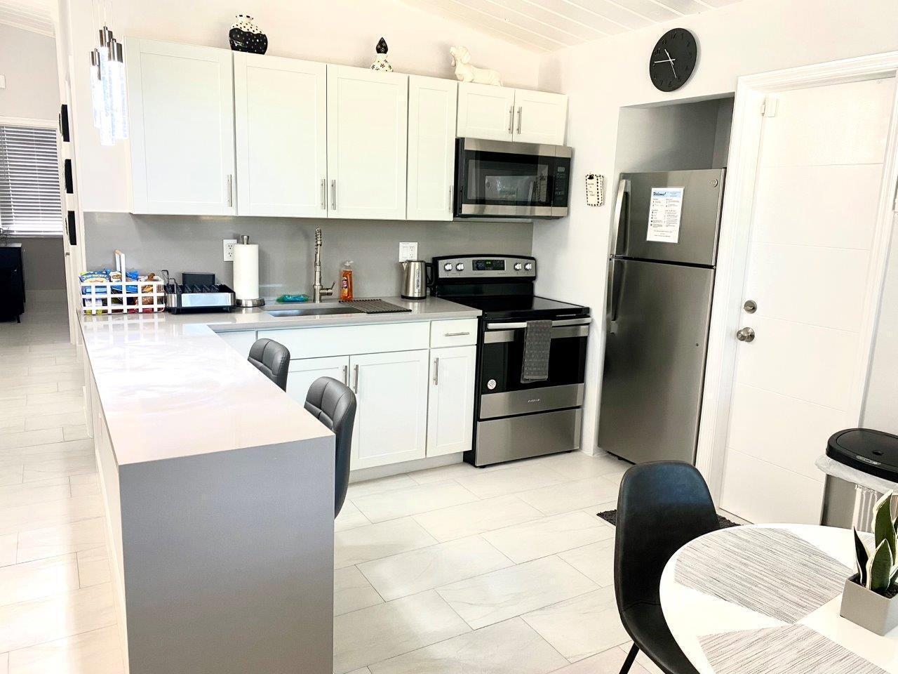 462 Hastings Street Boca Raton, FL 33487 - Photo 15 of 28 a kitchen with stainless steel appliances a stove a sink refrigerator and microwave