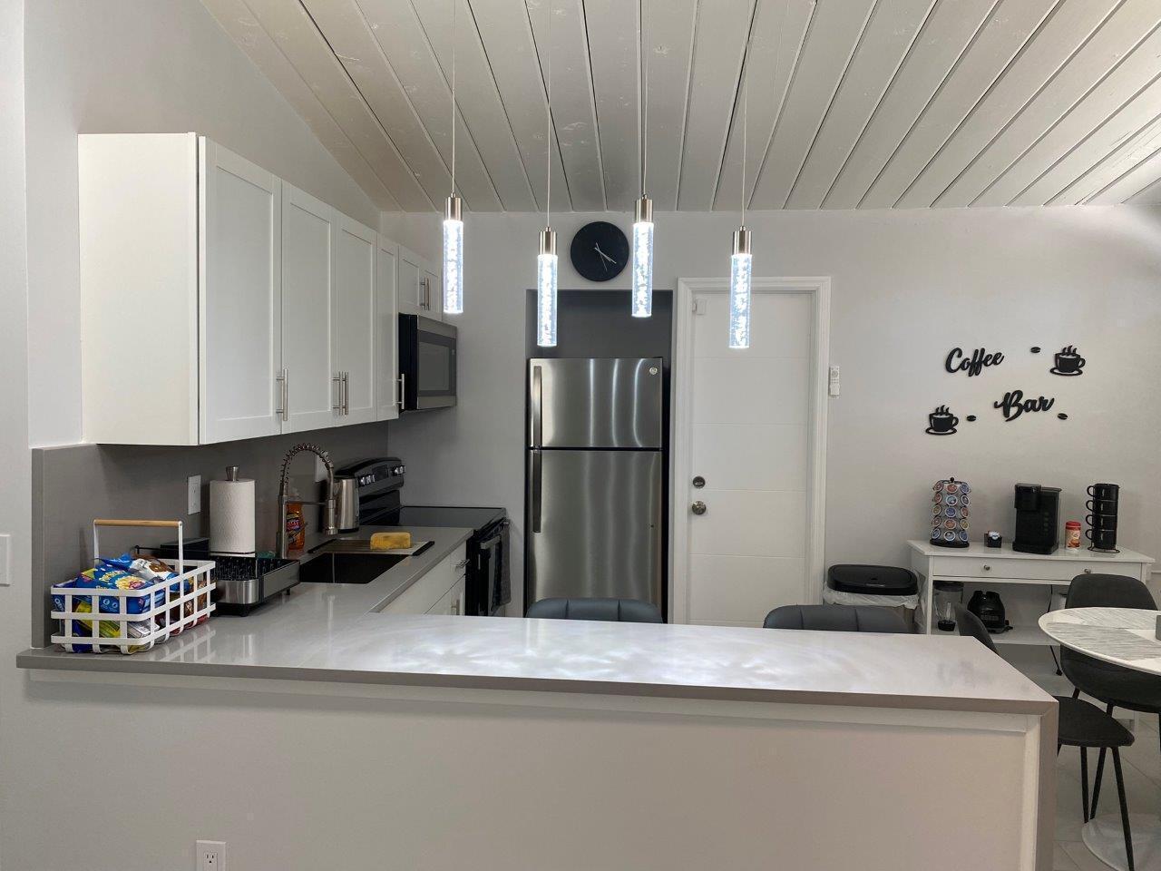 462 Hastings Street Boca Raton, FL 33487 - Photo 8 of 28 a kitchen with stainless steel appliances granite countertop a refrigerator a sink dishwasher and white cabinets with wooden floor