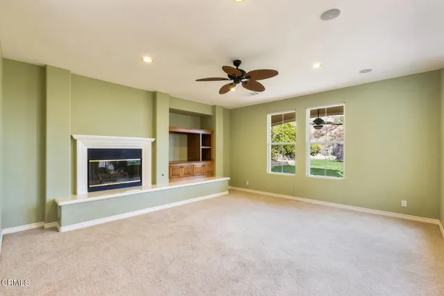 a view of an empty room with a window and a fireplace