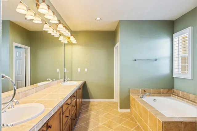 a bathroom with a tub sink and mirror