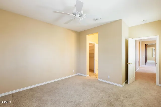 a view of a big room with windows and chandelier fan