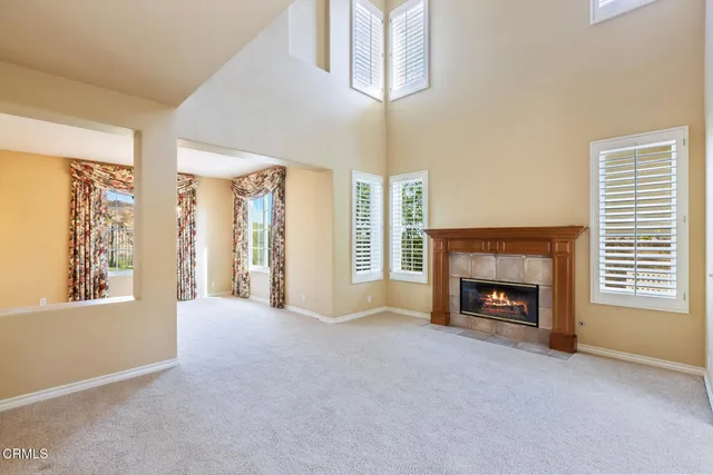 a view of an empty room with a fireplace and a window