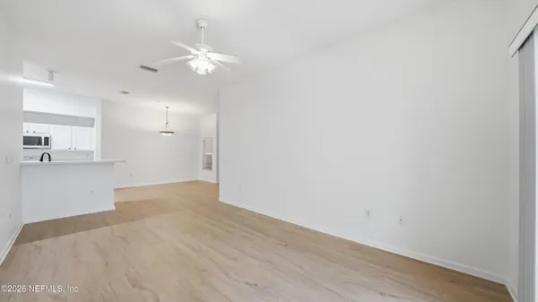 a view of a kitchen with wooden floor and a ceiling fan