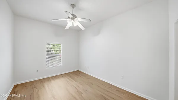 an empty room with a window and wooden floor