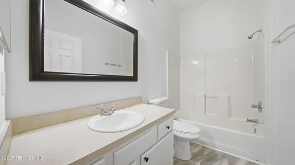 a bathroom with a toilet a sink a mirror and a bathtub