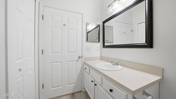 a bathroom with a sink vanity and a mirror