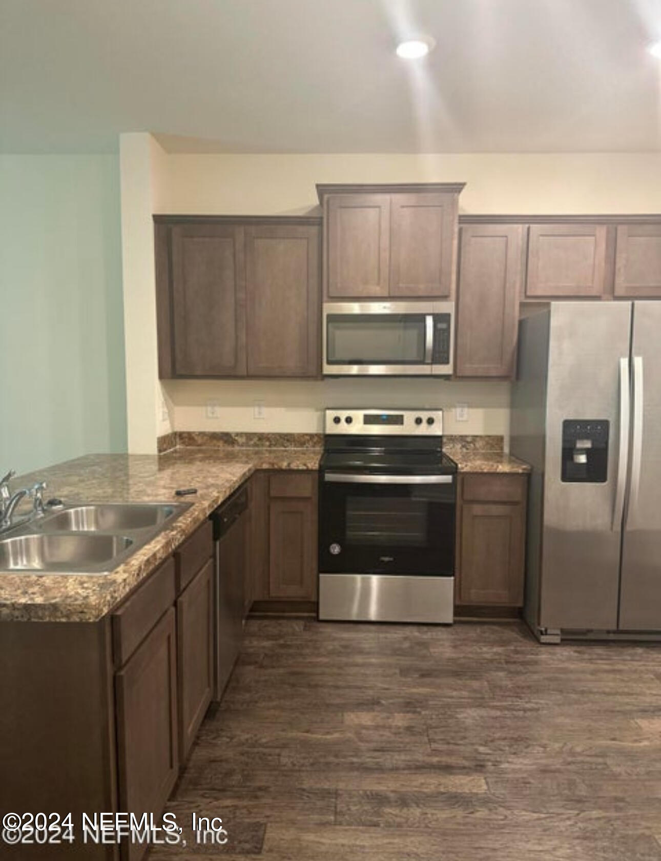 a kitchen with stainless steel appliances granite countertop a stove a sink and a refrigerator