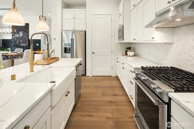 a large kitchen with stainless steel appliances kitchen island granite countertop a lot of counter space and wooden floors