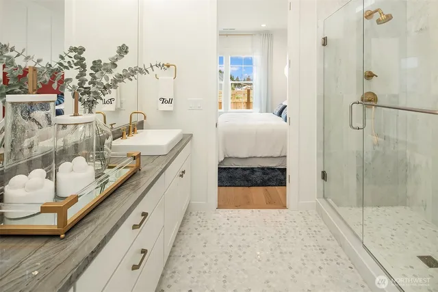 a en suite bathroom with a double vanity sink a mirror and shower