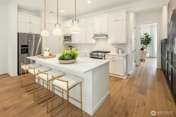 a kitchen with stainless steel appliances kitchen island granite countertop a stove a sink and a refrigerator
