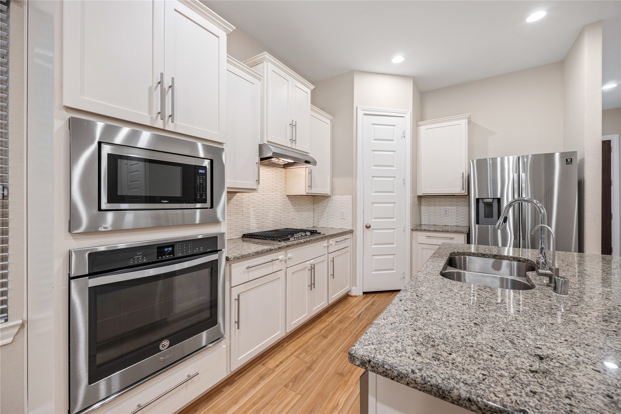 10408 Quiet Courtyard Road Houston, TX 77043 - Photo 7 of 24 White kitchen featuring built-in appliances and a clean, functional layout.