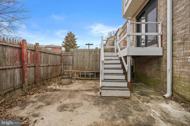 a view of a house with a small yard and wooden fence