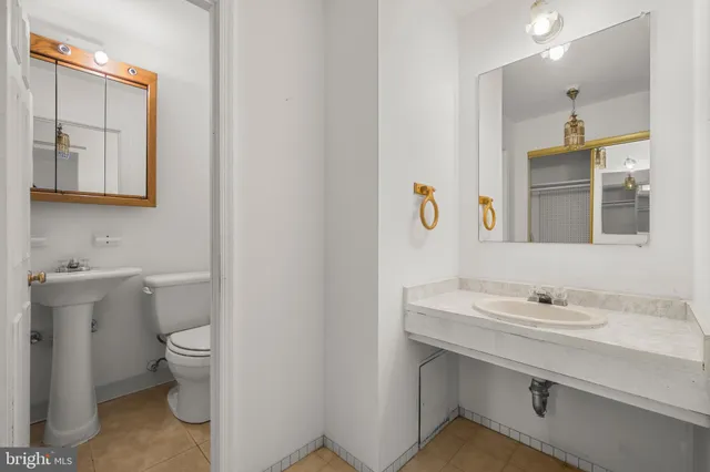 a bathroom with a sink toilet and mirror