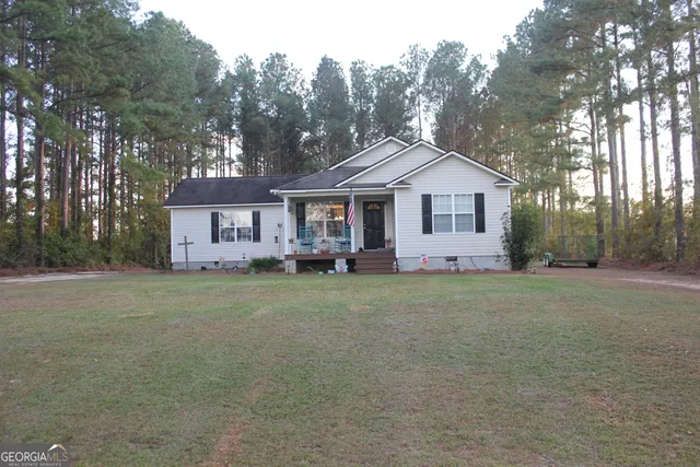 a front view of a house with a garden and trees