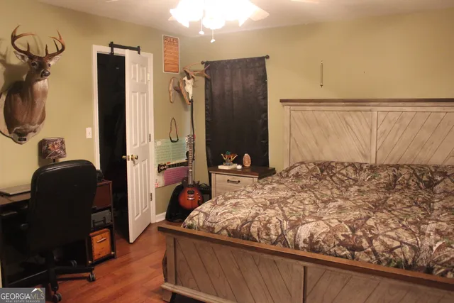a bedroom with a bed and wooden floor