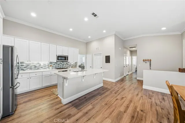 a kitchen with white cabinets and stainless steel appliances
