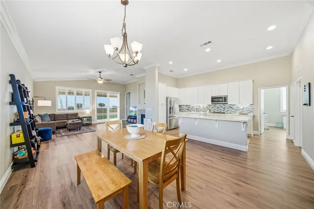 a view of a dining room and livingroom with furniture wooden floor a chandelier