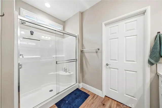 a bathroom with a glass shower door and a window