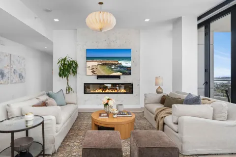 a living room with stainless steel appliances furniture large windows and a view of living room