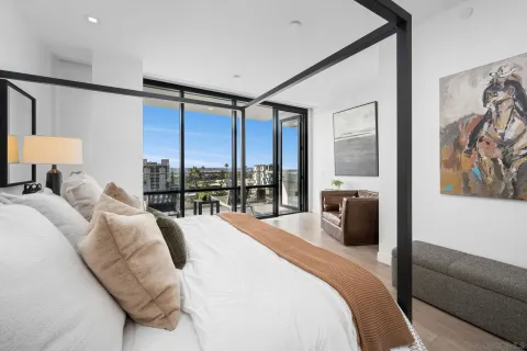 a bedroom with a bed and large windows